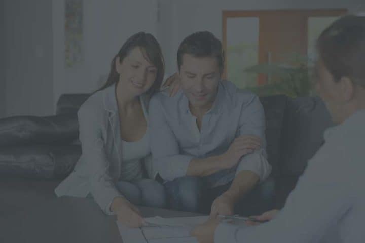 Couple signing documents with real estate agent