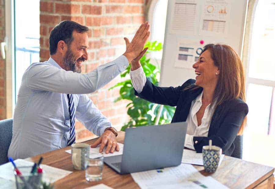 Agent and client smiling and high fiving