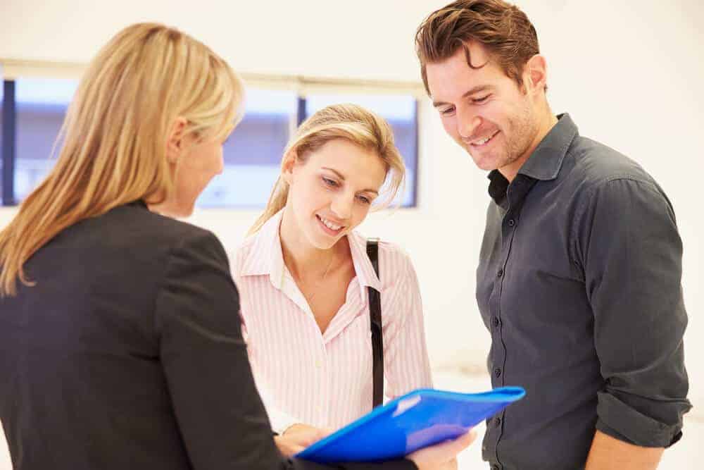 A commercial real estate consultiant in an empty commercial building with two clients.