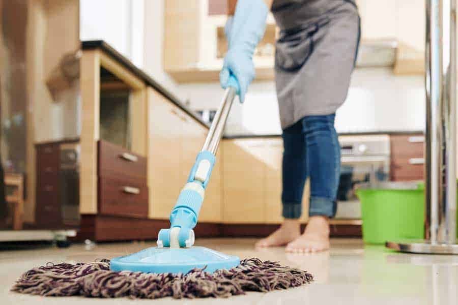 A woman mopping a kitchen floor