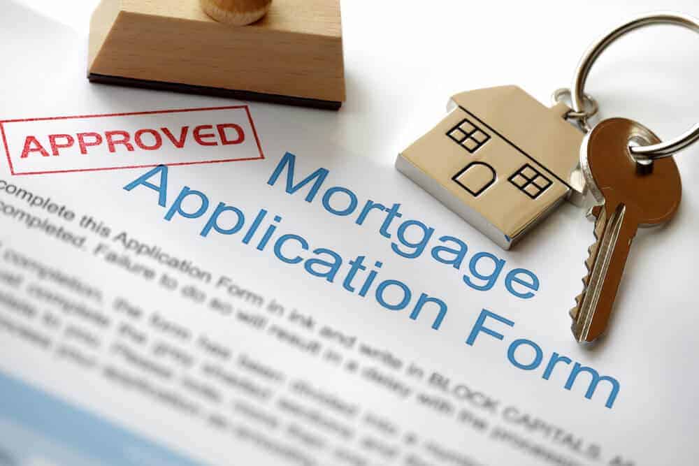 a mortgage application form, sptamped approved, with a house key