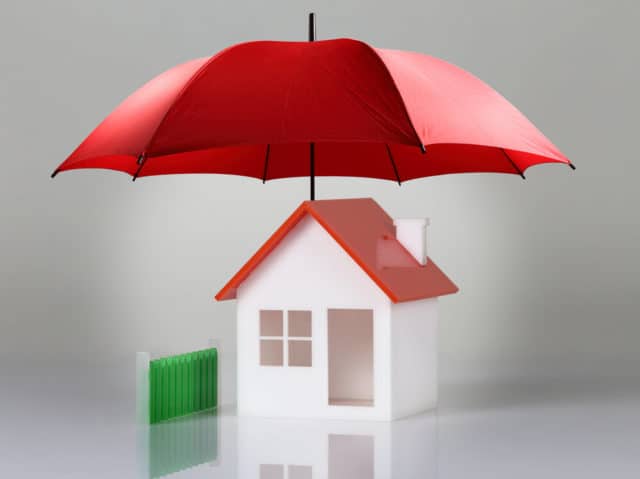 toy model of a home covered by an umbprlla, concept representing Home Warranty Program