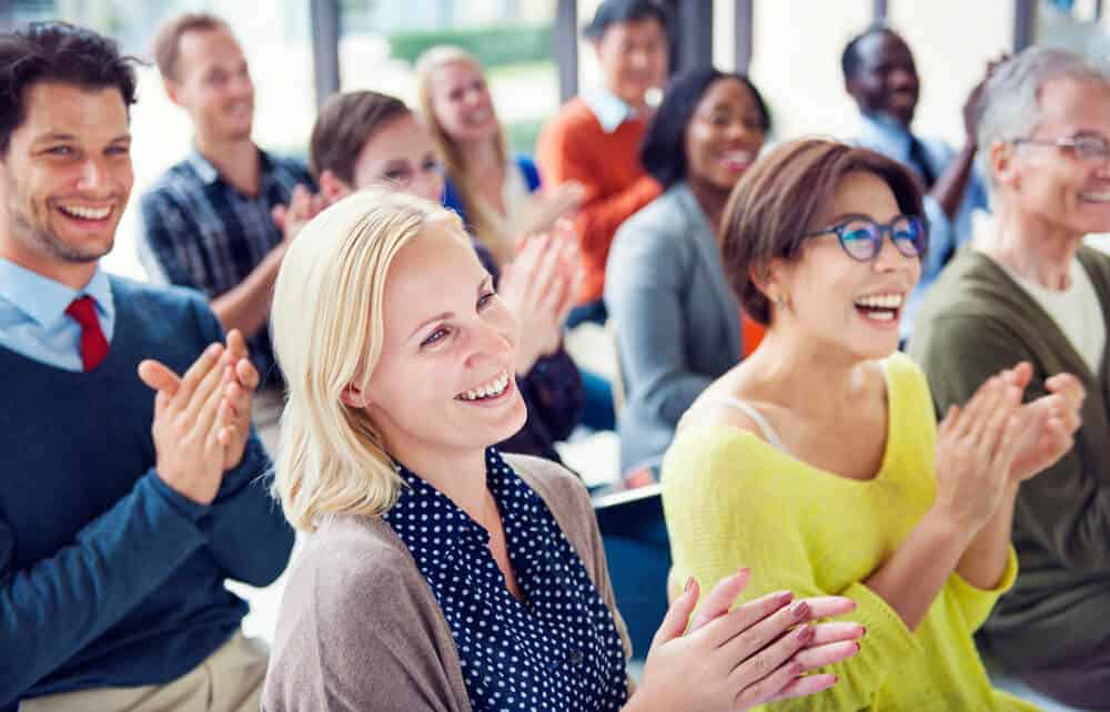 real estate agents smiling and clapping at a trianing seminar