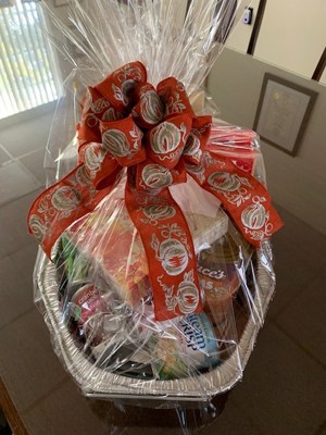gift basket wrapped and tied with a big red ribbon