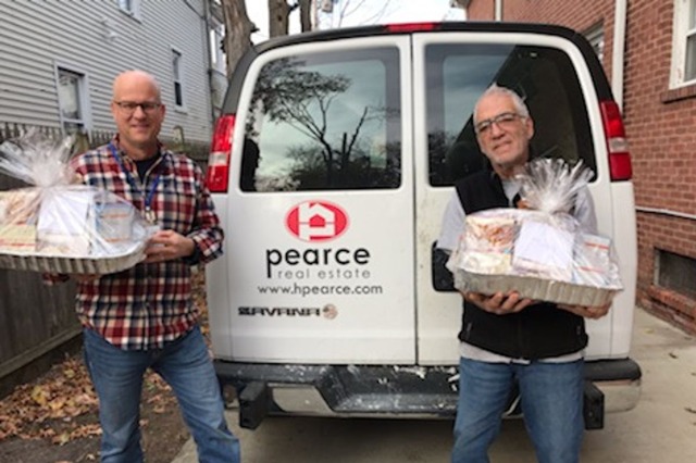 Two man holding gift baskets in front of a van